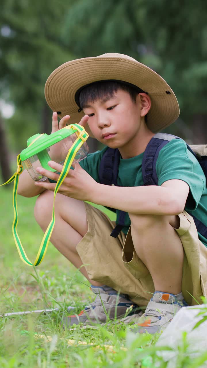 亚洲小学生在户外捉昆虫视频素材