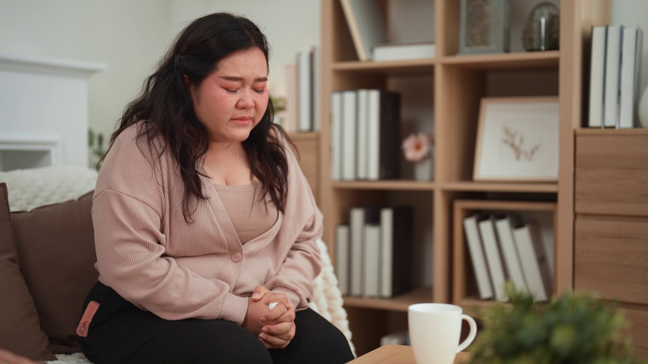 一名亚洲年轻成年肥胖女子在治疗过程中经历了一个糟糕的故事后，正在哭泣以减轻压力。视频素材