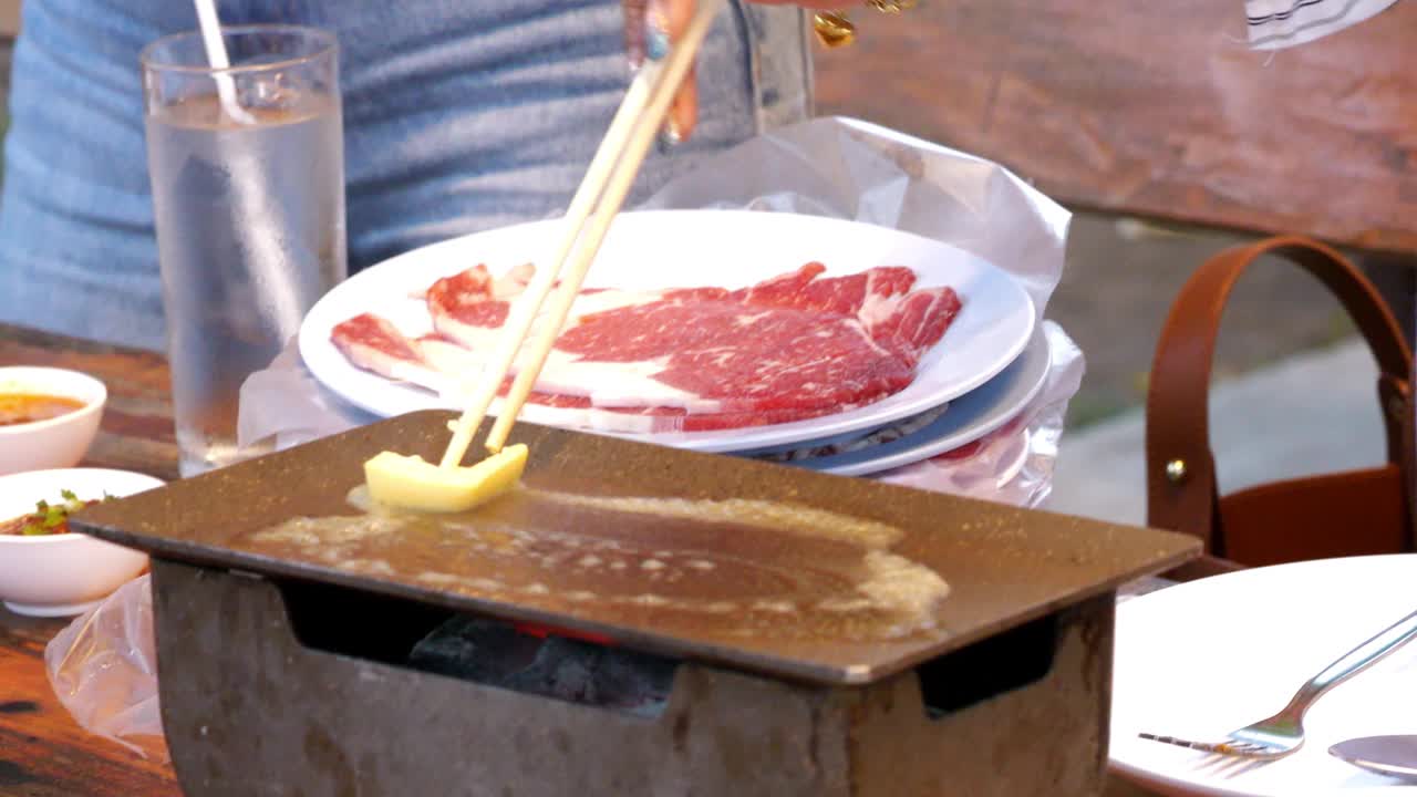 在餐馆烤牛排时，在热锅上涂黄油。视频素材