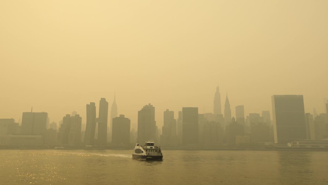 在朦胧的曼哈顿天际线前，纽约市渡轮漂浮在镜头前视频素材