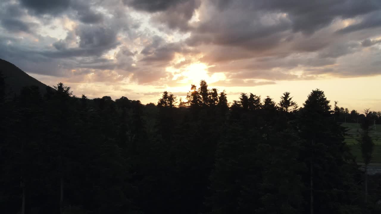 在平静的日落或黄昏时分，高空无人机拍摄鼓舞人心的高山景观，美丽的阳光泄漏和光束进入框架。迷人的夏日和观赏自然的概念视频素材