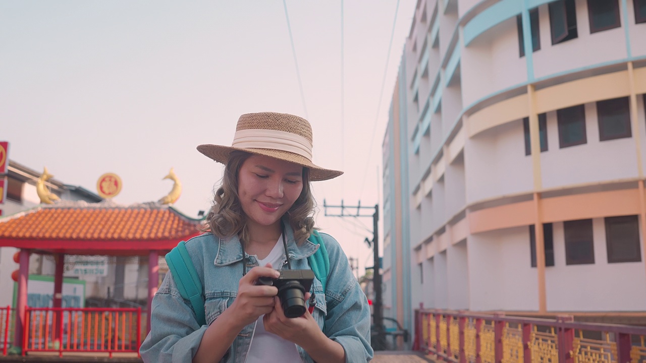 年轻的亚洲女性背包旅行者在城市中使用相机。旅行的生活方式。世界旅游探索者或亚洲夏季旅游概念。视频素材