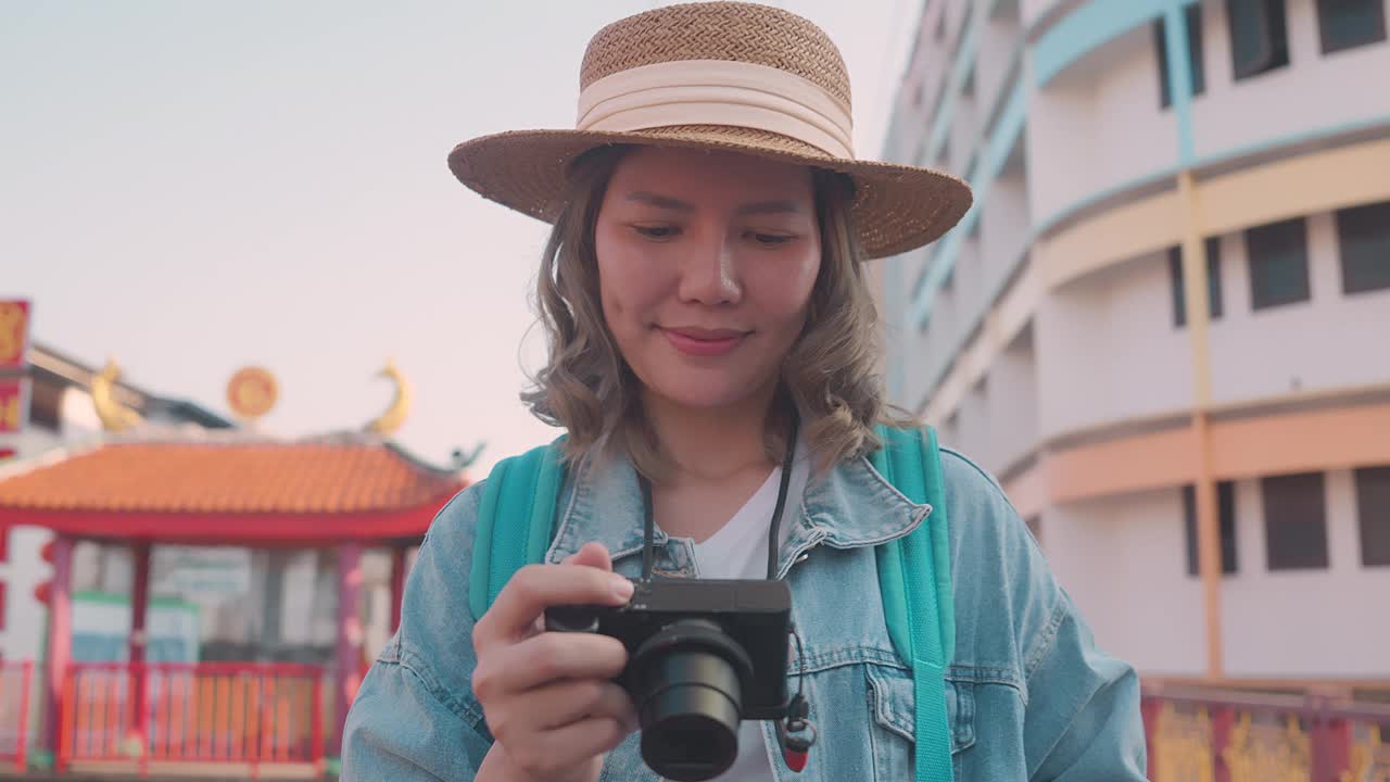 年轻的亚洲女性背包旅行者在城市中使用相机。旅行的生活方式。世界旅游探索者或亚洲夏季旅游概念。视频素材