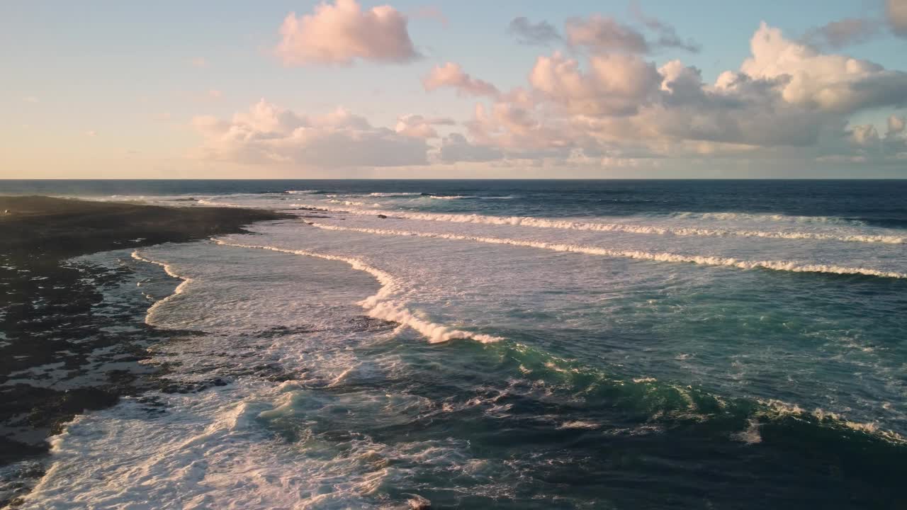 海浪拍打着海岸，飞过水面，夕阳西下。视频素材