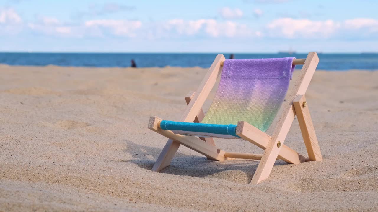 阳光明媚的假期，在沙滩上玩沙滩玩具。空太阳躺椅站海海洋背景。木制沙滩椅。暑假假期视频素材