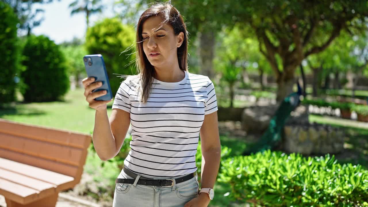 一名中东女子微笑着自信地在公园用手机自拍视频素材