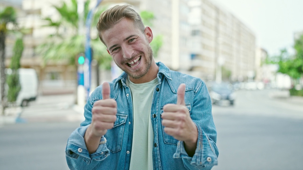 年轻的白人男子微笑着自信地做着ok的手势，在街上竖起大拇指视频素材