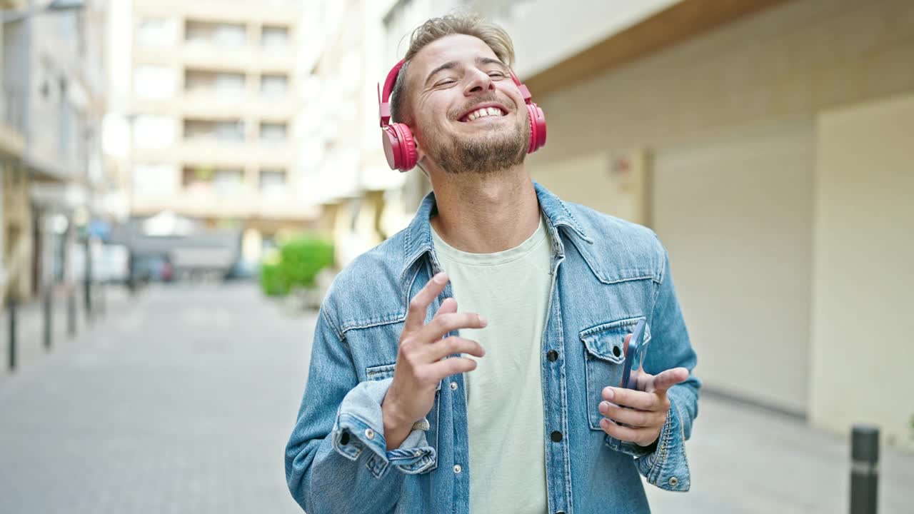 年轻的白人男子在街上听音乐跳舞视频素材