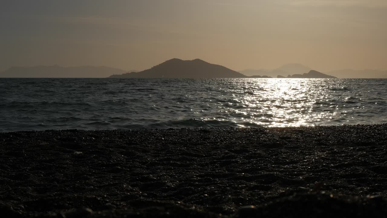 傍晚，孩子的剪影在海湾上奔跑。视频素材