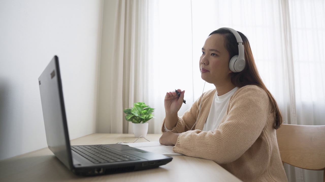 戴着耳机的女商人在家里通过视频会议开会视频素材