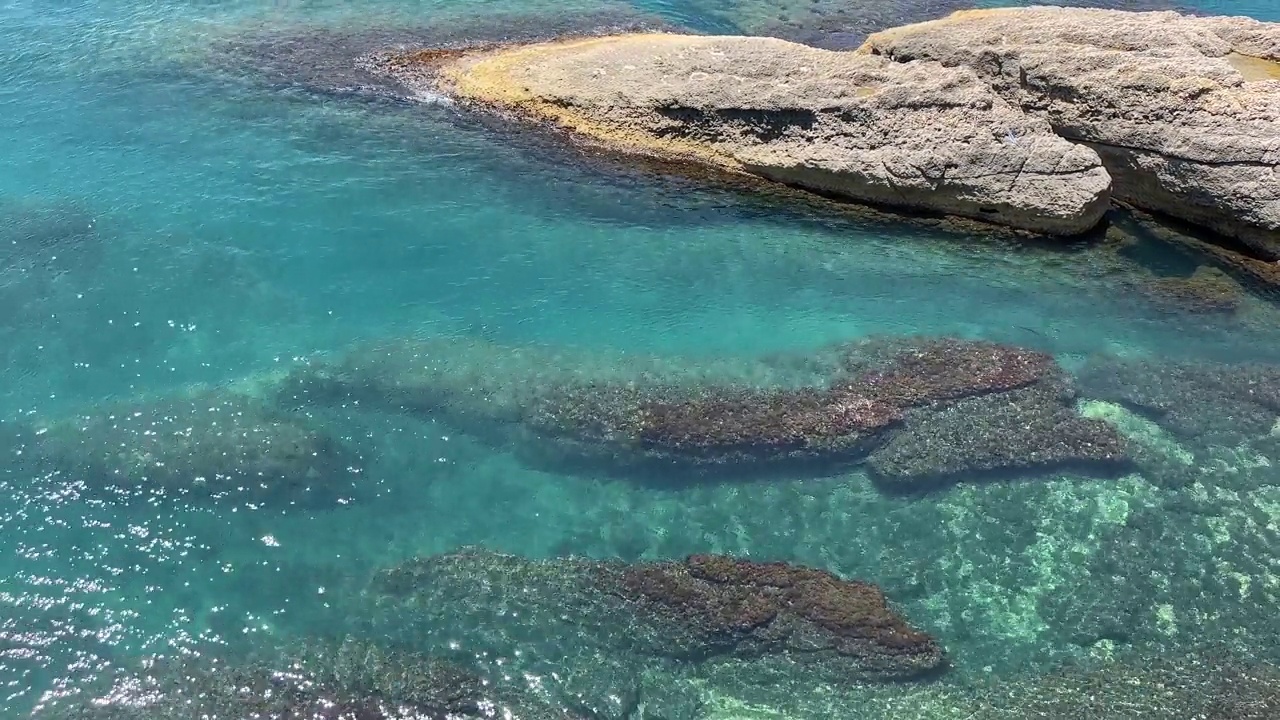 海水碧蓝的水面和美丽的岩石海岸鸟瞰。视频素材