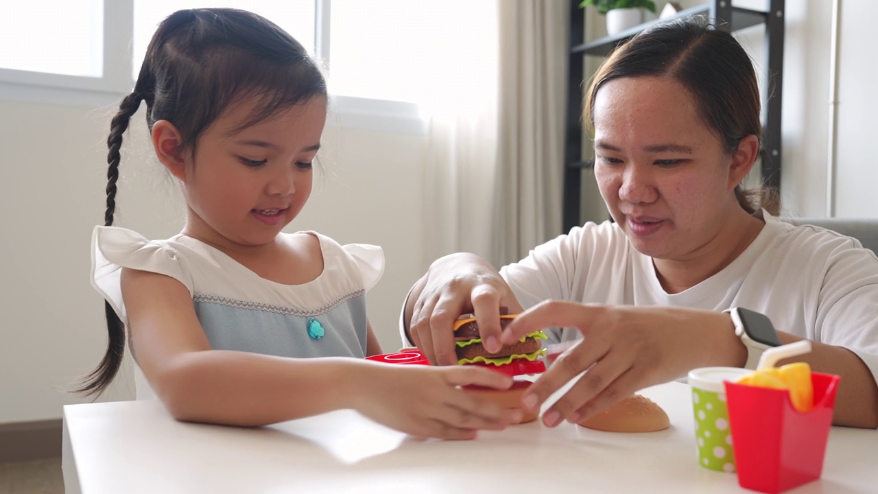 在想象中，妈妈和小女孩一起玩塑料儿童玩具视频素材