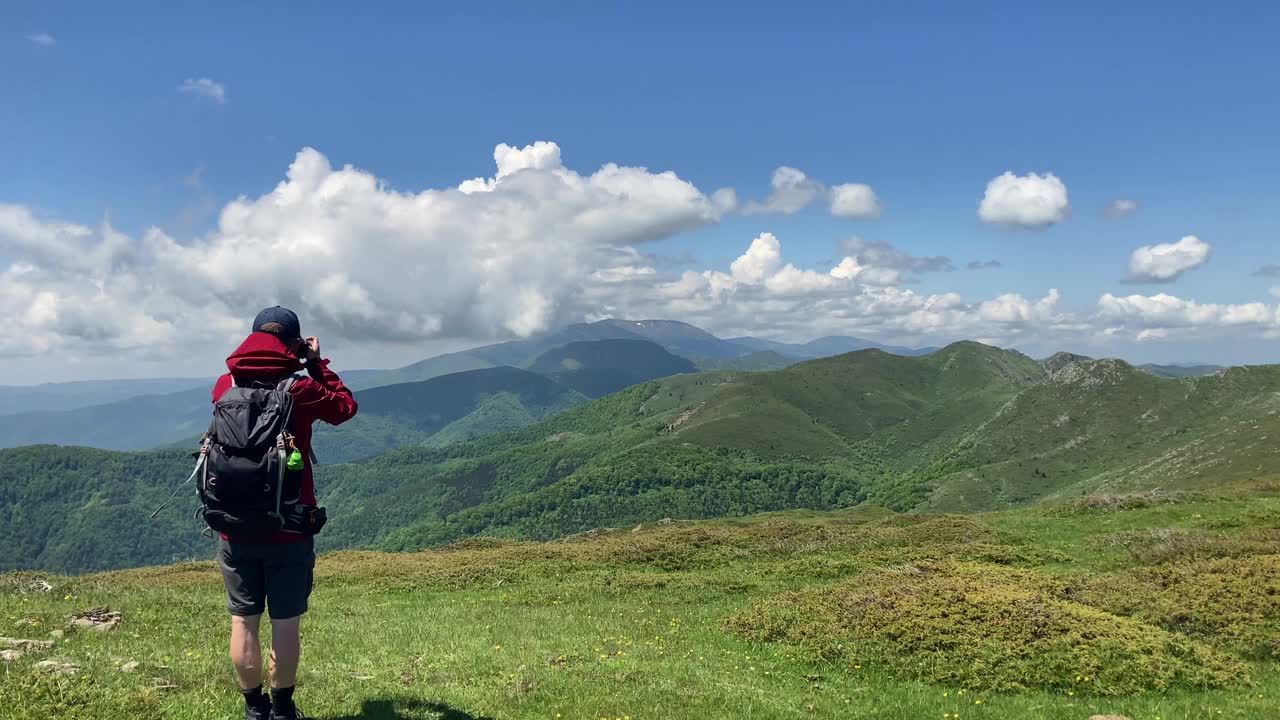 男徒步旅行者欣赏连绵起伏的山脉——保加利亚，欧洲。视频素材