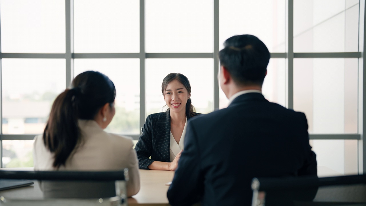 图为，一名亚洲女性应聘者在面试结束后，正在与面试委员会握手。视频素材