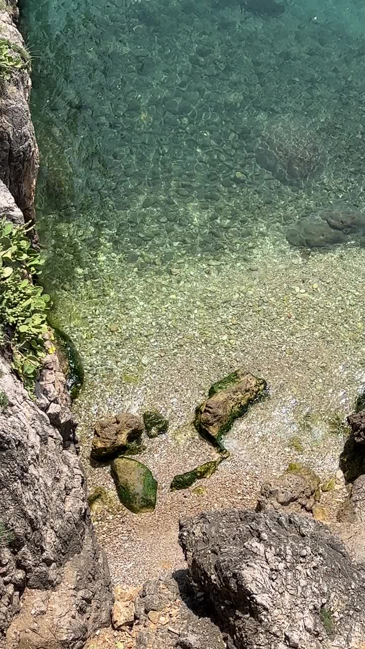 蔚蓝的海水和风景秀丽的岩石海岸鸟瞰图，垂直视频。视频素材