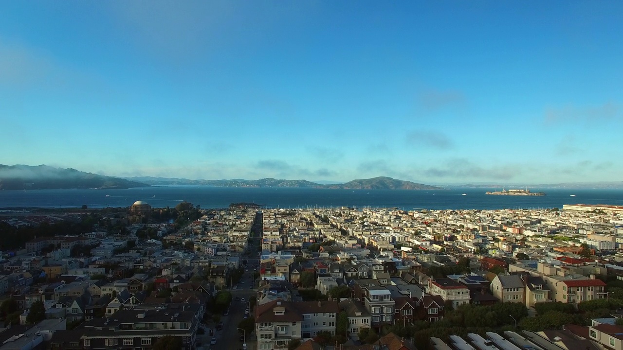 航拍的街道和房屋在郊区的天空，无人机在城市附近的海上向后飞行-旧金山，加利福尼亚视频素材