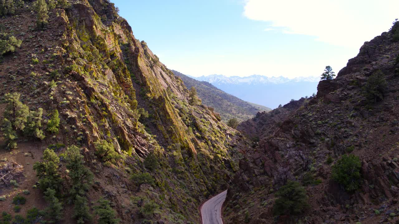 空中拍摄的空蜿蜒的道路在山对天空，无人机向前飞越山谷-猛犸湖，加利福尼亚视频素材