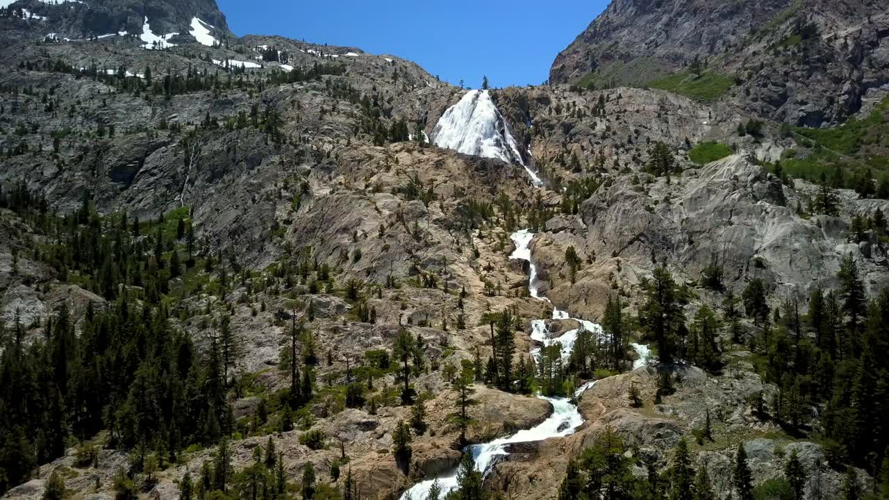 空中拍摄的瀑布在山脉对天空，无人机上升向前在自然景观-猛犸湖，加利福尼亚视频素材