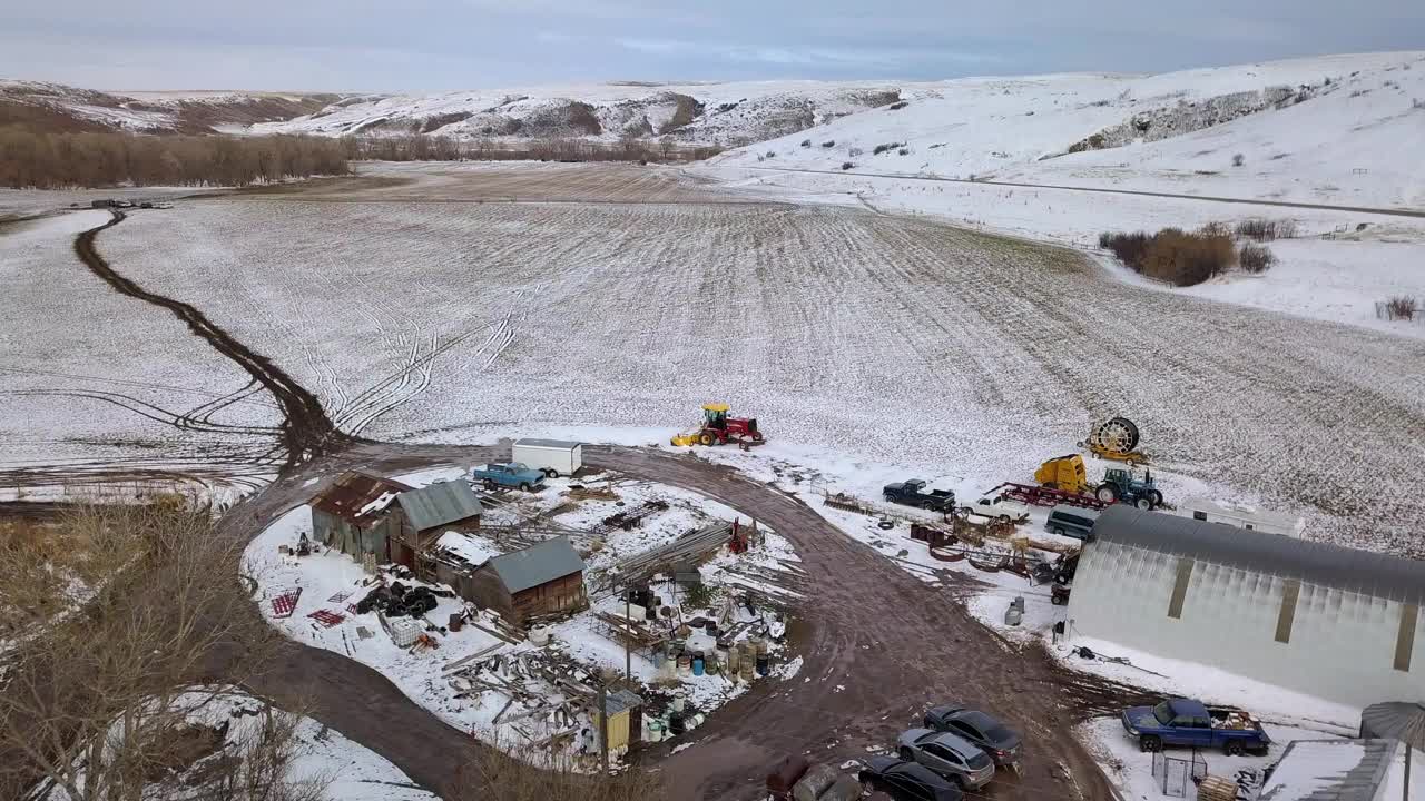 空中倾斜拍摄的建筑物和车辆由光秃秃的树，无人机飞行在雪景对天空-比林斯，蒙大拿州视频素材