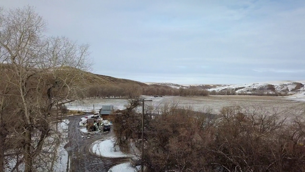 空中平移拍摄的空旷道路附近的雪结构，无人机向前飞行的景观对天空-比林斯，蒙大拿州视频素材