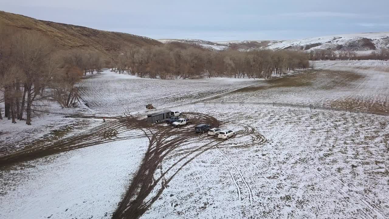 空中平移拍摄的人和车辆光秃秃的树在雪地上，无人机飞行在景观对天空-比林斯，蒙大拿州视频素材