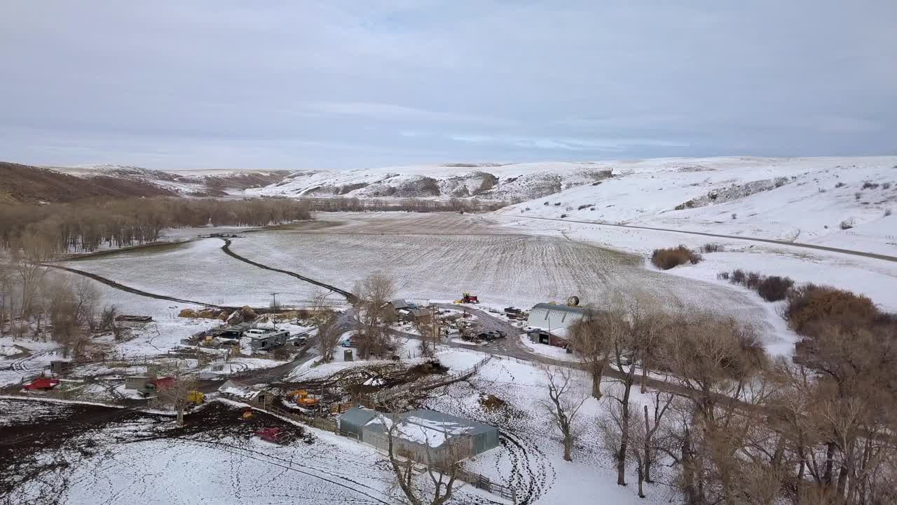 空中拍摄的建筑物和车辆由光秃秃的树木对着天空，无人机在雪景飞行向前-比林斯，蒙大拿州视频素材