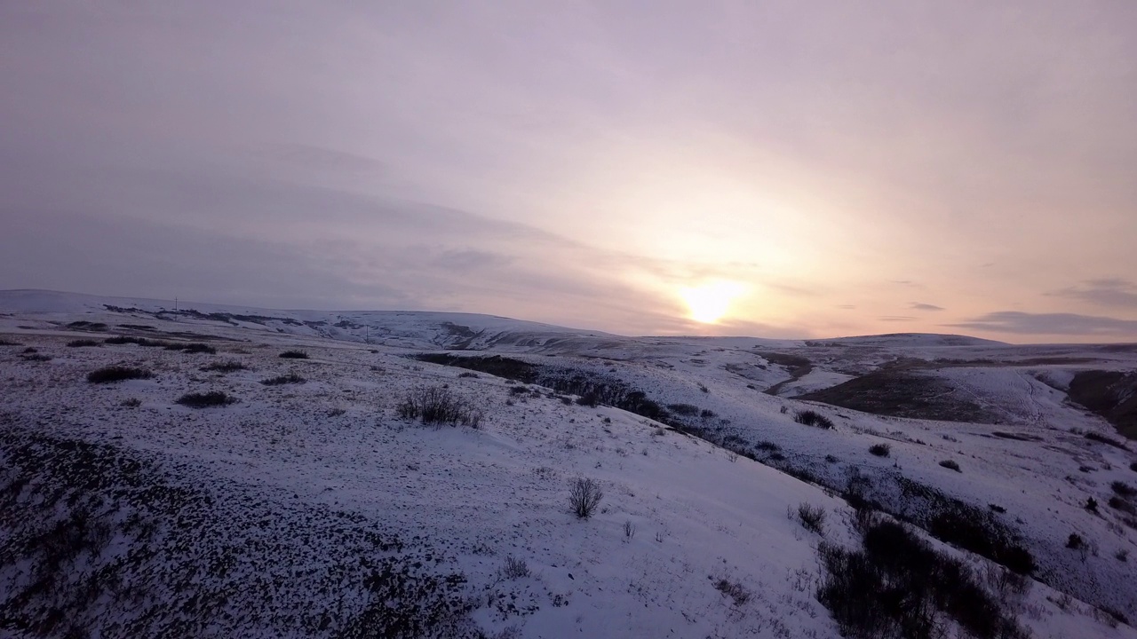 空中拍摄的雪山附近的道路对多云的天空，无人机飞越景观在日落-比林斯，蒙大拿州视频素材