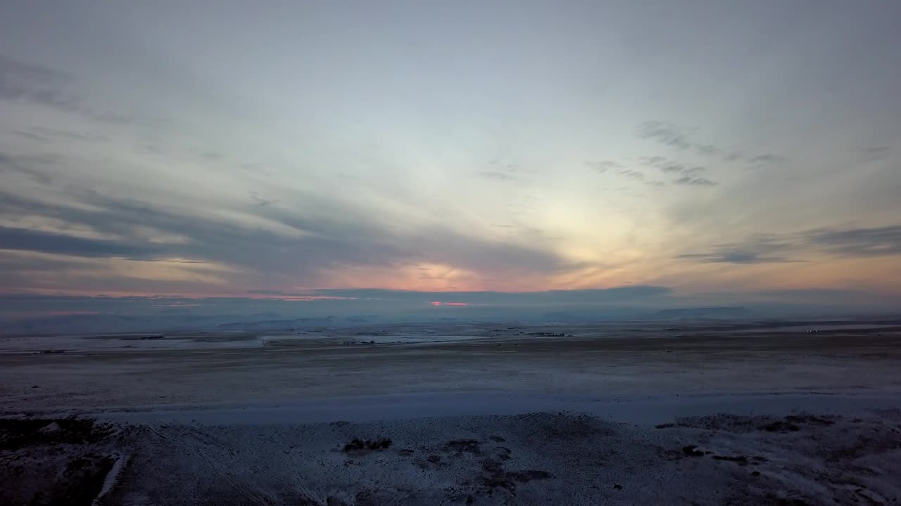 空中平移拍摄的雪景对多云的天空在日落-比林斯，蒙大拿州视频素材