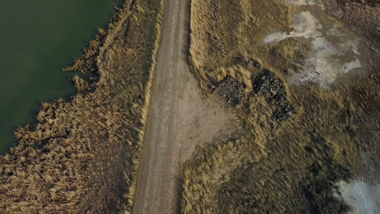 空中倾斜拍摄的乡村道路，风景优美的河流对着天空，无人机向后飞行在景观-比林斯，蒙大拿州视频素材