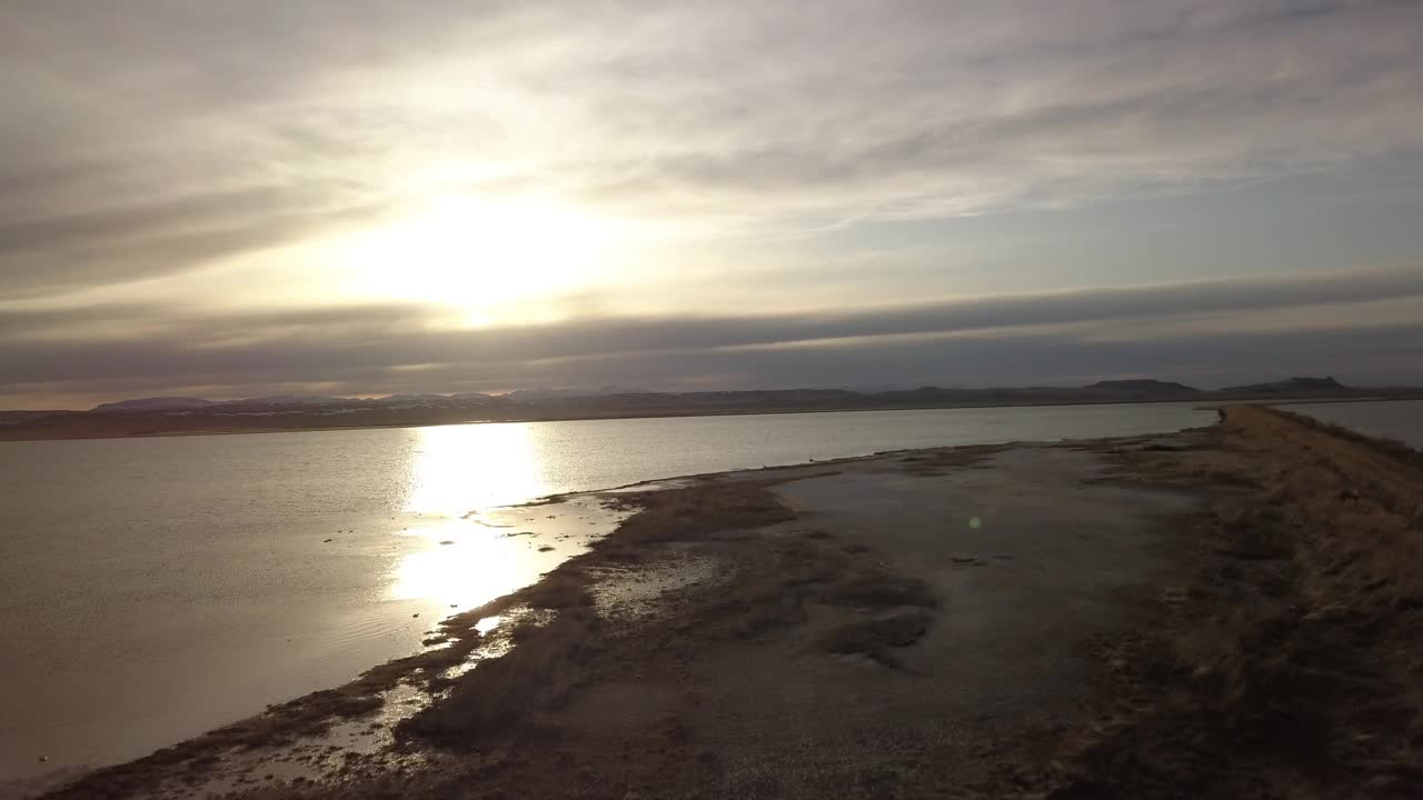 日落时，无人机在水面上向前飞行，从空中拍摄的风景优美的河流视频素材