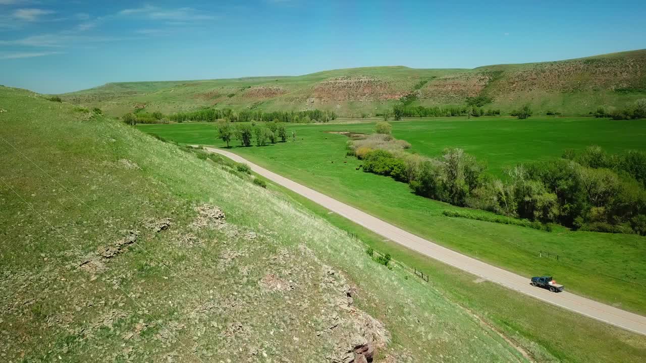 空中拍摄的皮卡车在乡村道路上移动对天空比林斯，蒙大拿州视频素材