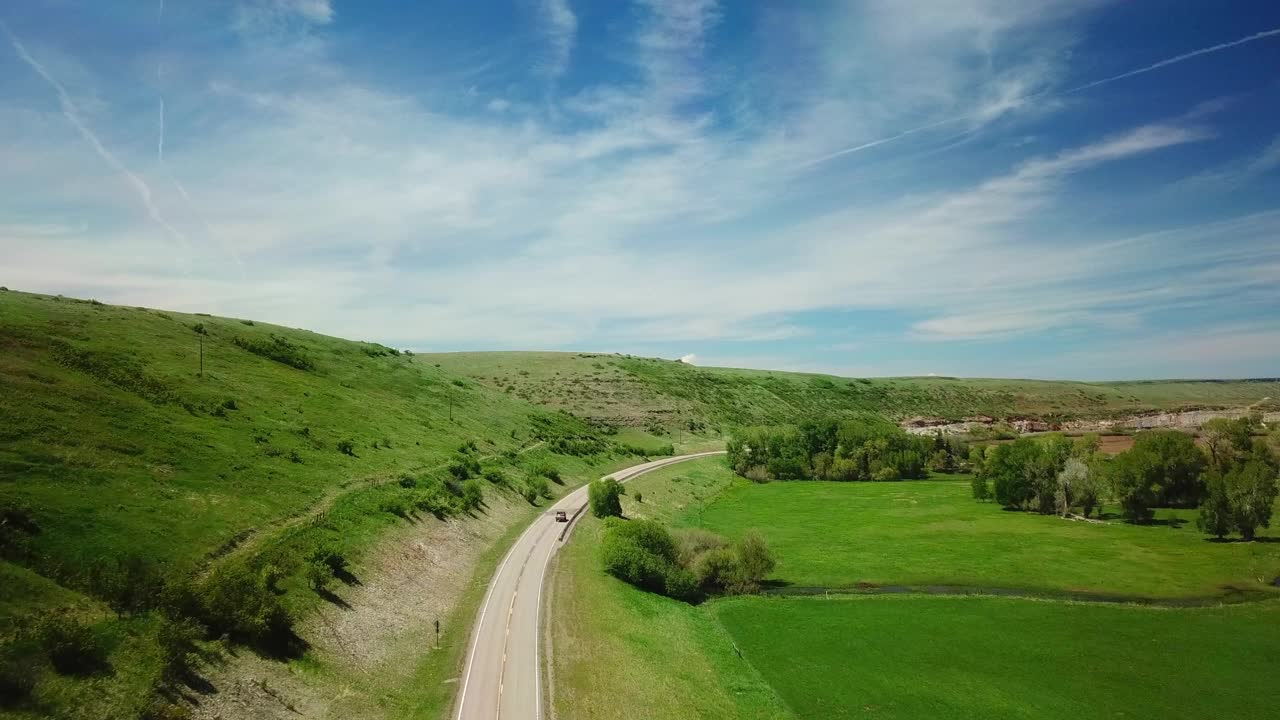 空中拍摄的皮卡车在山路上移动对天空比林斯，蒙大拿州视频素材