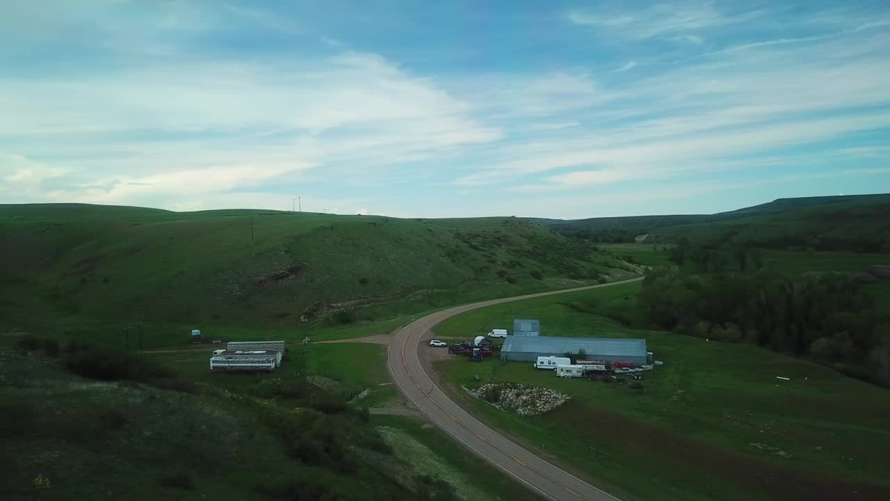 空中慢动作拍摄的卡车移动的道路上通过绿色山脉对天空-比林斯，蒙大拿州视频素材