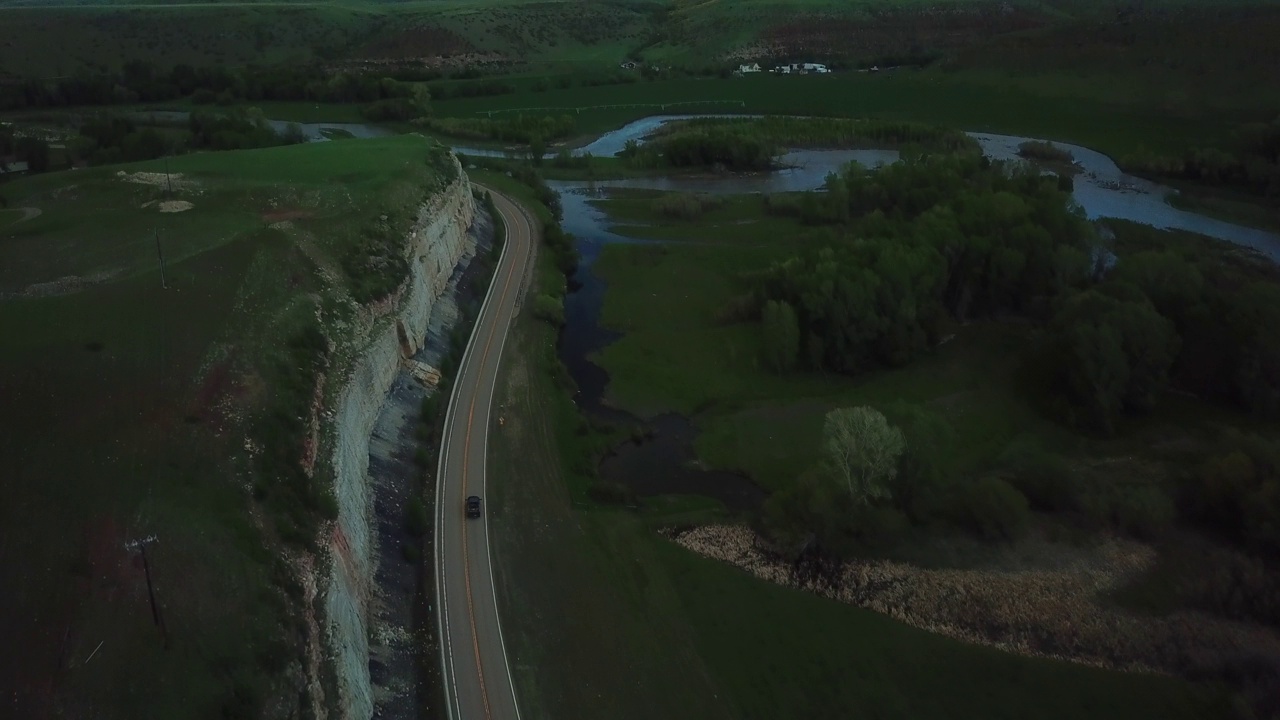 空中倾斜拍摄的皮卡在公路上通过山对天空-比林斯，蒙大拿州视频素材