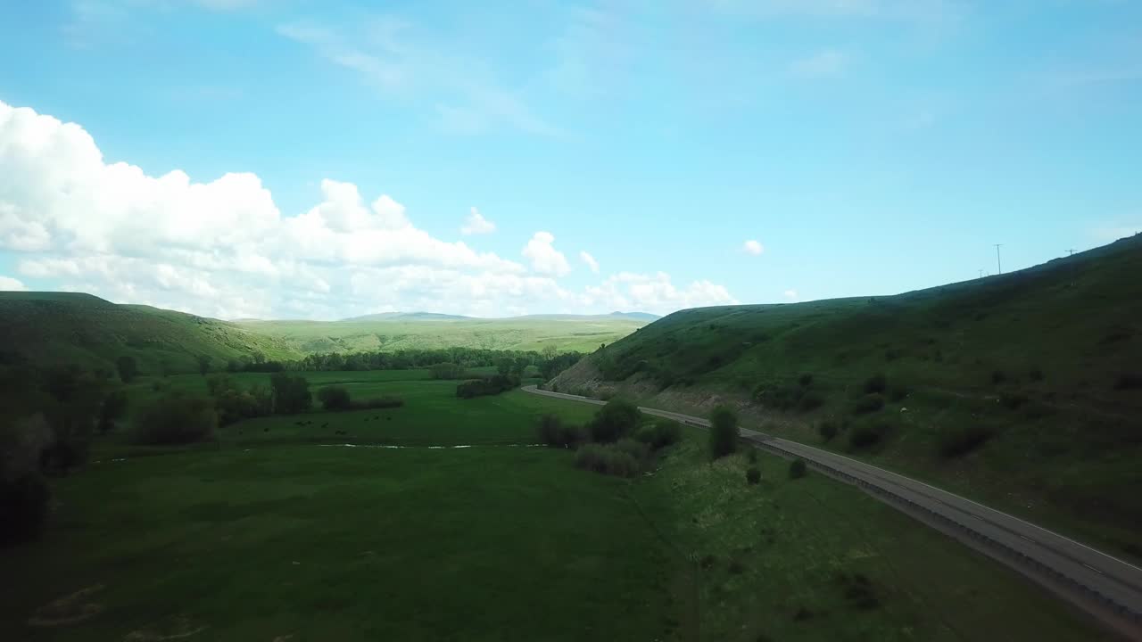 空中向前拍摄的道路通过风景秀丽的山对天空-比林斯，蒙大拿州视频素材