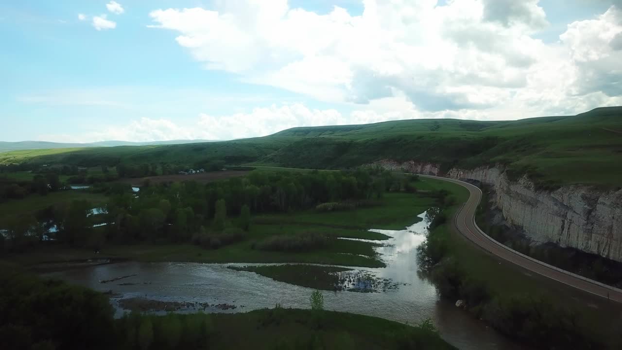 空中慢动作拍摄的道路通过悬崖对天空，无人机向前飞行在景观-比林斯，蒙大拿州视频素材