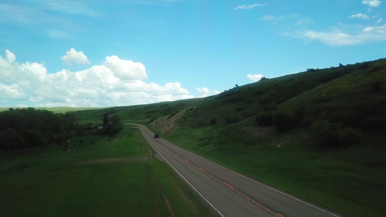 空中前进慢动作镜头的皮卡移动的道路上通过山对天空-比林斯，蒙大拿州视频素材