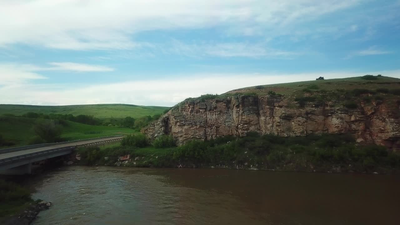 航拍的车辆在乡村道路上通过河流，无人机在水面上向前飞行-比林斯，蒙大拿州视频素材