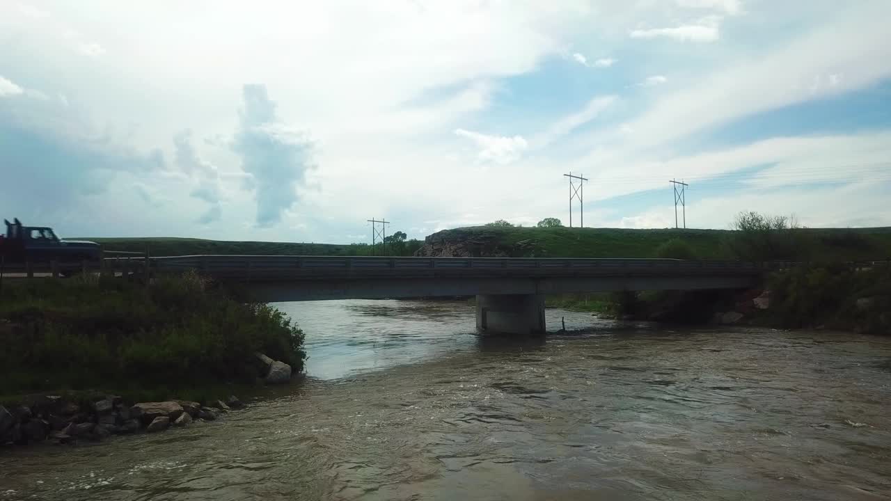 航拍的车辆在河上的道路上移动，无人机在水上向上飞行-比林斯，蒙大拿州视频素材