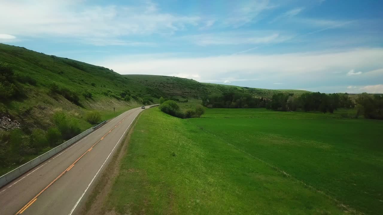 在蒙大拿州比林斯，前方航拍的车辆穿过山脉的道路视频素材