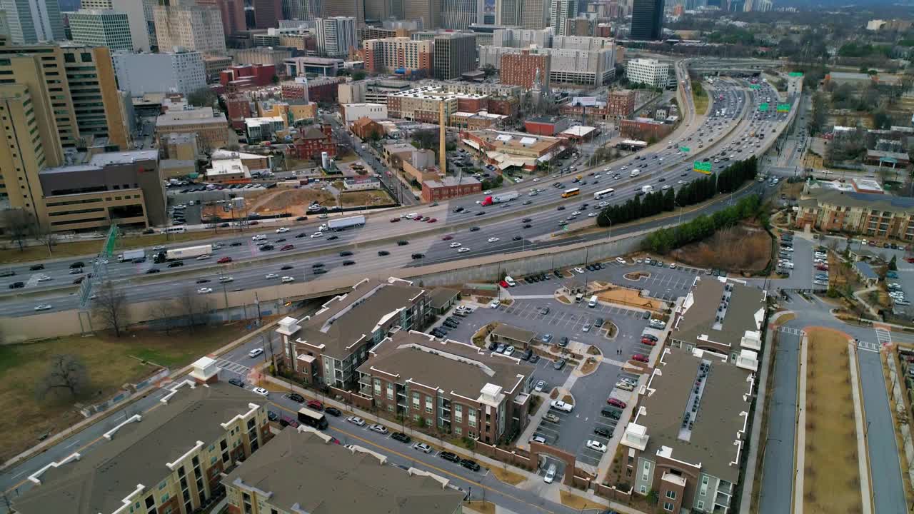 空中倾斜拍摄的道路上的交通，建筑物对着天空，无人机在城市上空向后飞行-亚特兰大，乔治亚州视频素材