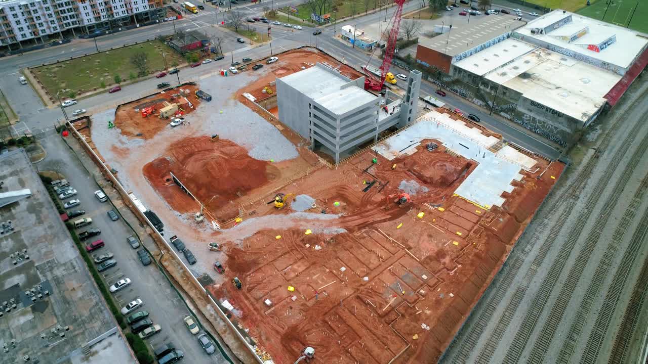 空中倾斜拍摄的建筑工地附近的铁路在城市，无人机飞越城市景观多云的天空-亚特兰大，乔治亚州视频素材