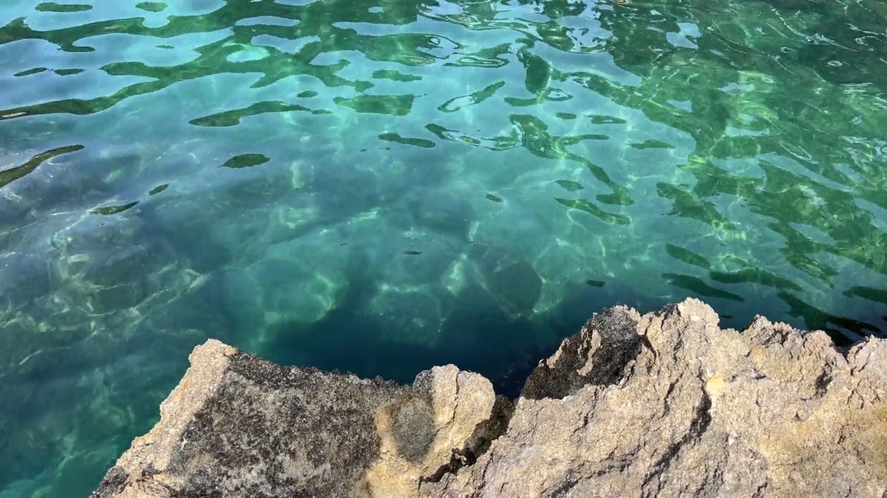 碧蓝清澈的海水和海岸岩石。视频素材