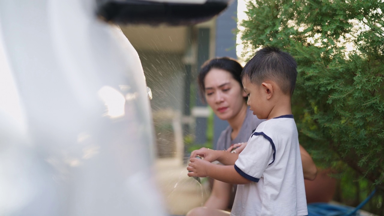 小男孩和妈妈一起洗车视频素材