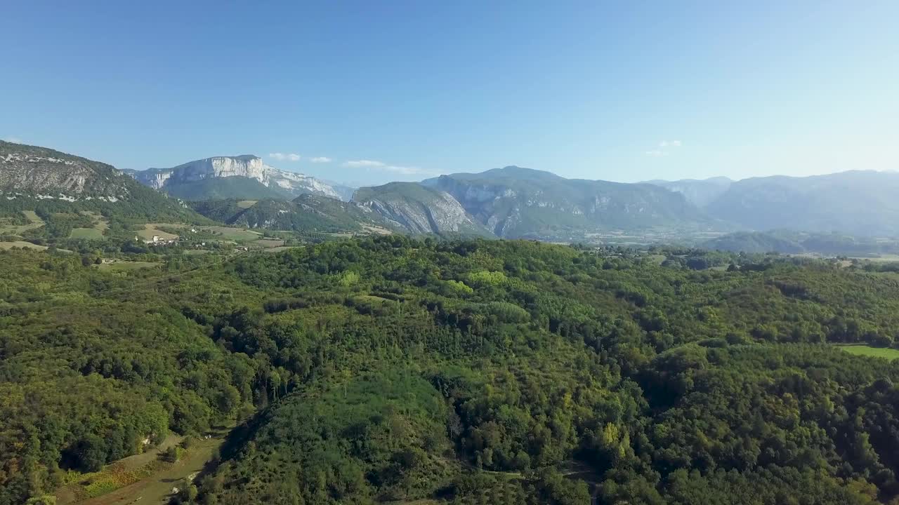 在阳光明媚的日子里，无人机俯瞰森林茂密的山脉视频素材