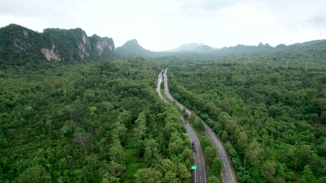 乡村道路的俯视图，穿过绿色的森林和山视频素材