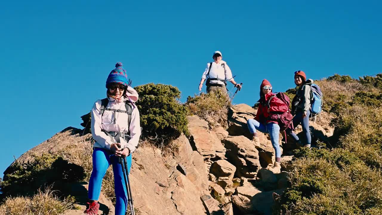 徒步旅行者站在山顶上看风景。视频素材