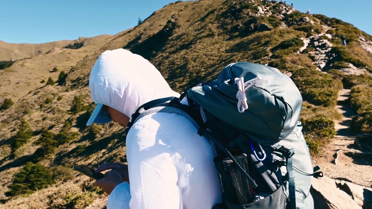 登山客在山顶使用智能手机。视频素材