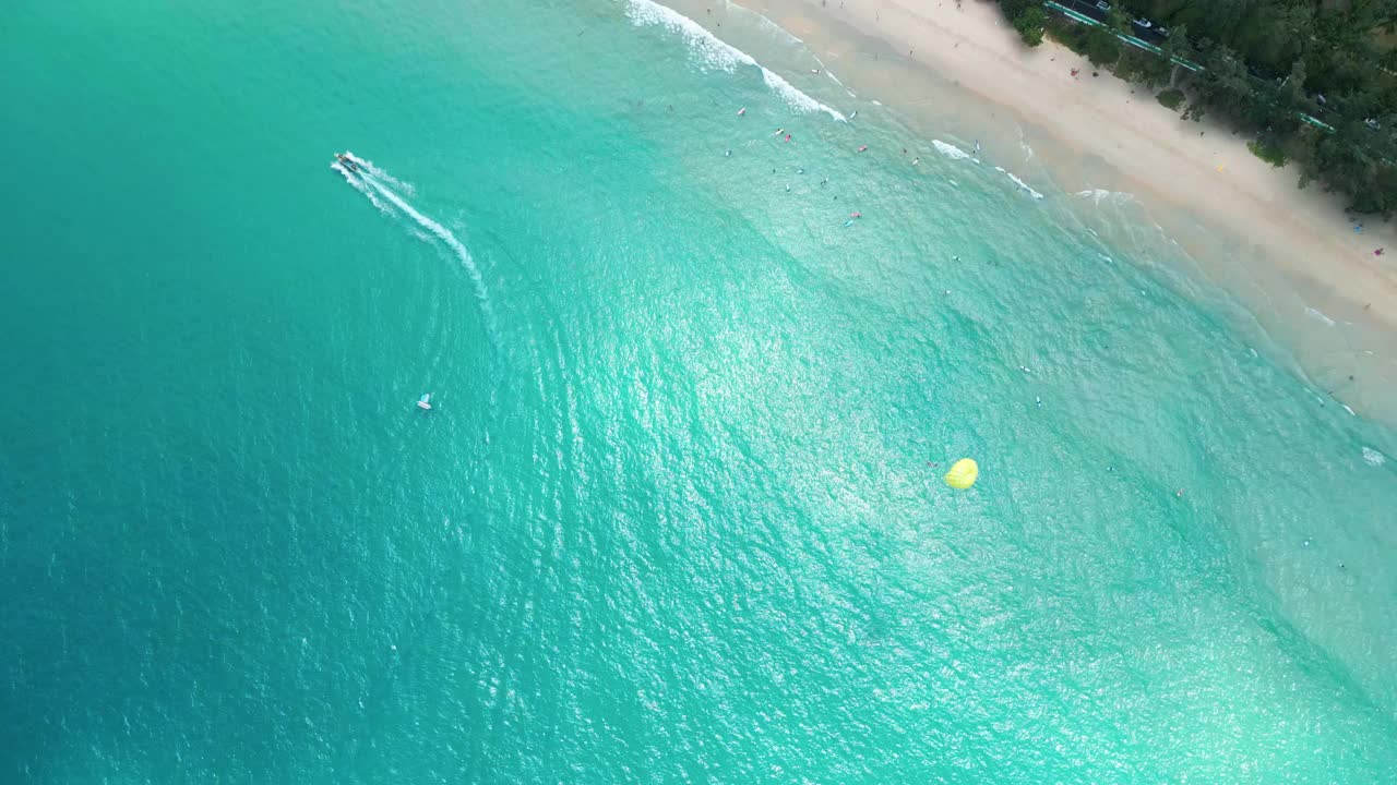 鸟瞰图两艘快艇拖着滑翔伞在大海和青山之间穿梭。普吉岛,泰国视频素材