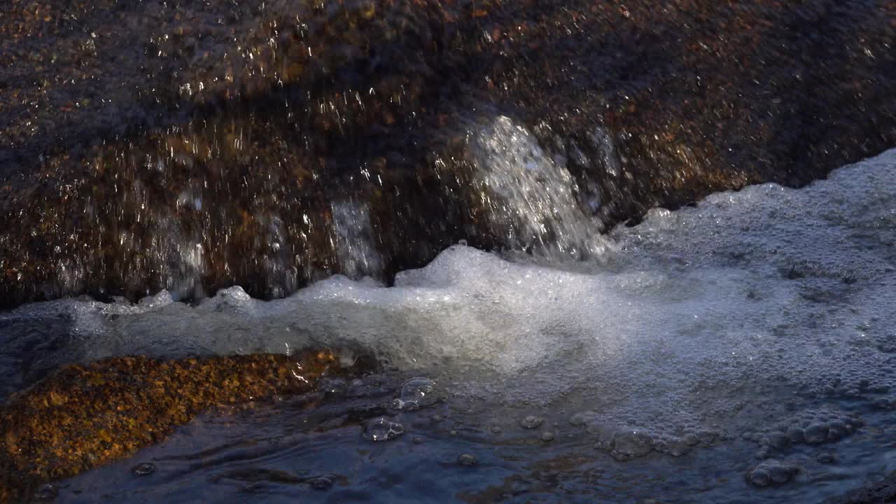 水在岩石上冒泡的特写视频素材